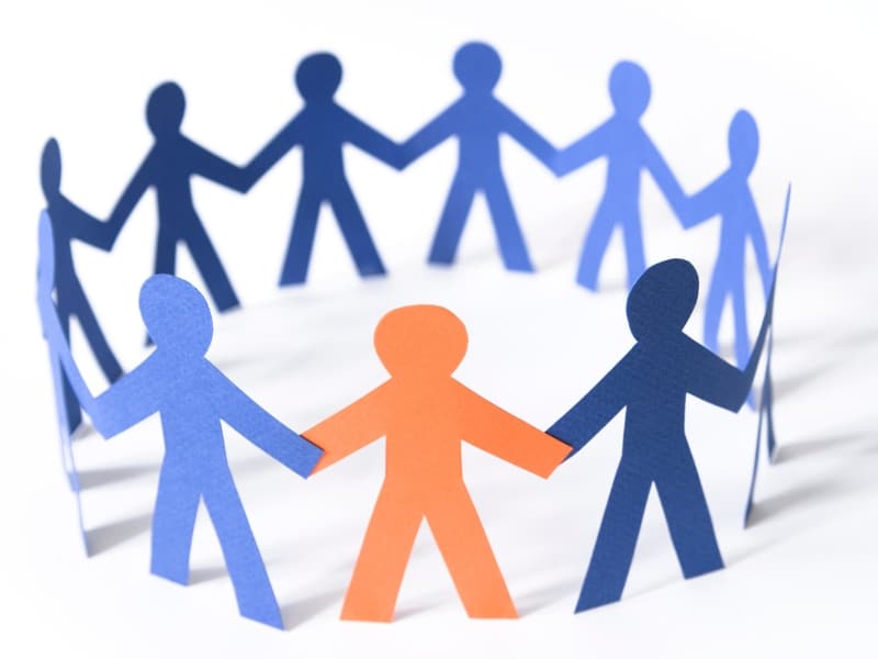 Paper cut-out figures in a circle symbolising unity and social support chronic illness concept in a supportive community.